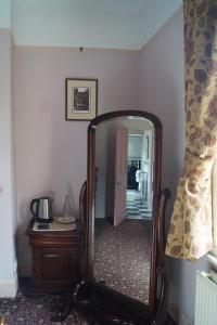 a mirror in a room with a chair and a table at Foundry Masters House in Ironbridge