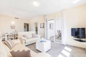 a living room with a couch and a tv at Villa Marismas Sombra in Son Bou