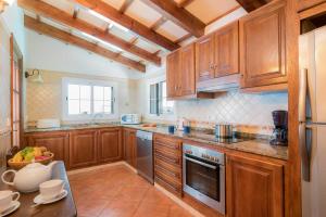 ビニベカにあるVilla Maribelの木製のキャビネットとカウンタートップを備えたキッチン