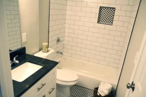 a white bathroom with a sink and a toilet at The Orange Door-Sleeps 10 in Louisville