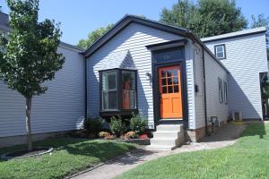a small house with an orange door in a yard at The Orange Door-Sleeps 10 in Louisville