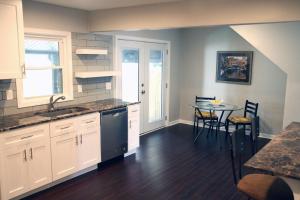 a kitchen with a sink and a table with chairs at The Orange Door-Sleeps 10 in Louisville