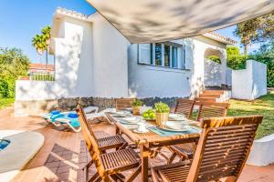 a patio with a table and chairs and a house at Villa Marismas Sombra in Son Bou