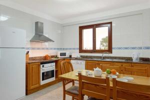 eine Küche mit einem Tisch und einem weißen Kühlschrank in der Unterkunft Villa Animeta in Pollença