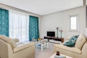 ein Wohnzimmer mit 2 Sofas und einem TV in der Unterkunft Villa Coral Bay in Peyia