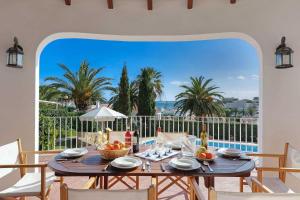 comedor con mesa y vistas al océano en Villa Fantasia, en Punta Prima