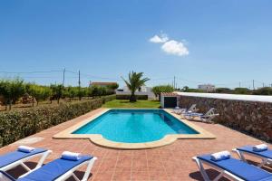 una piscina con 2 tumbonas y una piscina en Villa Verde en Tres Alquerías