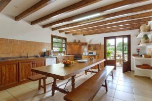 cocina grande con mesa de madera y bancos en Finca Plomera, en Pollensa