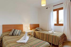 zwei Betten in einem Hotelzimmer mit Handtüchern darauf in der Unterkunft Villa Animeta in Pollença