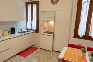 a kitchen with white cabinets and a refrigerator at Ca Riolfo, appartamento a due passi da Rialto in Venice