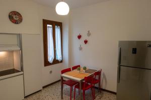 a kitchen with a table and chairs and a refrigerator at Ca Riolfo, appartamento a due passi da Rialto in Venice