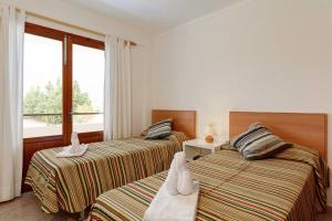 zwei Betten in einem Zimmer mit Fenster in der Unterkunft Villa Animeta in Pollença