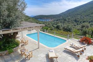 een zwembad met ligstoelen en een huis bij Villa Leda in Sivota