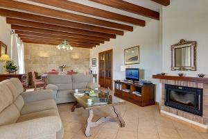 a living room with a couch and a fireplace at Villa Deu Quarterades in Santanyi