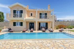 a villa with a swimming pool in front of a house at Villa Argostoli Bay in Argostoli