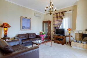 a living room with a couch and a television at Villa Kalithea in Argostoli