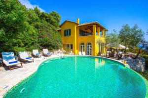 a swimming pool in front of a house at Villa Elpida in Sivota