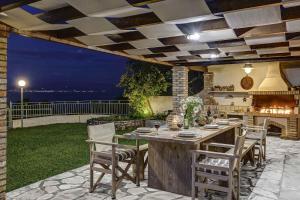 an outdoor patio with a table and chairs and a grill at Villa Irida in Apraos