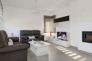 sala de estar con 2 sofás y chimenea en Villa Iris en Frigiliana
