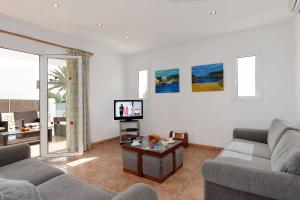 sala de estar con 2 sofás y TV en Villa Sagitaro, en Cala d´Or