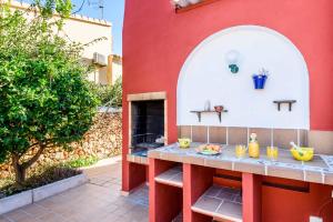 a red building with a table with fruit on it at Villa Paula in Cala'n Porter