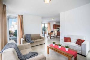 ein Wohnzimmer mit zwei Sofas und einem Tisch in der Unterkunft Villa White Daisy in Peyia