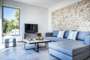 a living room with a blue couch and a table at Villa Della Luna in Vlachata
