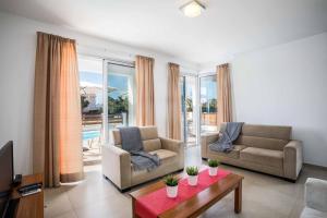 ein Wohnzimmer mit zwei Sofas und einem Tisch in der Unterkunft Villa White Daisy in Peyia