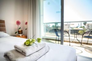 ein Schlafzimmer mit Handtüchern auf einem Bett mit Fenster in der Unterkunft Villa White Daisy in Peyia + 10 Fotos