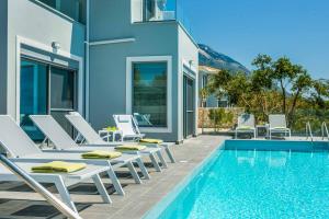 a villa with a swimming pool and lounge chairs at Villa Della Luna in Vlachata