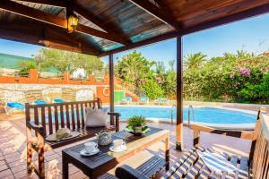 a patio with a table and chairs and a swimming pool at Villa Paula in Cala'n Porter