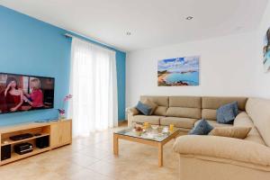 a living room with a couch and a tv at Blue Dream in Cala en Forcat