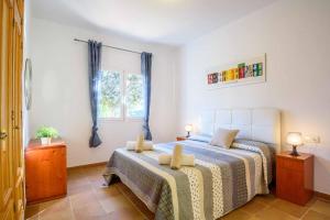 a bedroom with a bed and a window at Villa Paula in Cala'n Porter +13 photos
