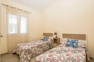 um quarto com 2 camas e uma janela em Villa Alana em Es Mercadal