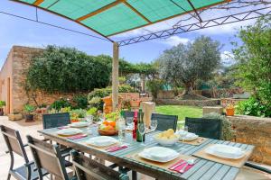 a wooden table with a bowl of fruit and a bottle of wine at Villa Mestressa in Santanyi