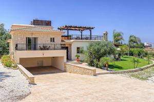 Una casa grande con un balcón en la parte superior. en Villa Yialos, en Neo Chorio