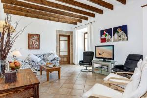 a living room with a couch and a tv at Villa Mestressa in Santanyi