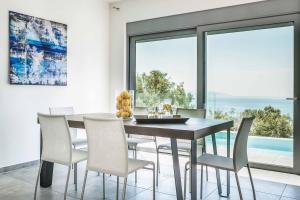 a dining room with a table and chairs and a large window at Villa Del Cielo in Vlachata