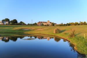 a golf course with a pond in the foreground at Bowood Park Hotel in Camelford