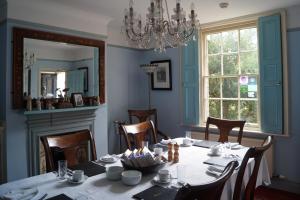 a dining room with a table and a chandelier at Foundry Masters House in Ironbridge