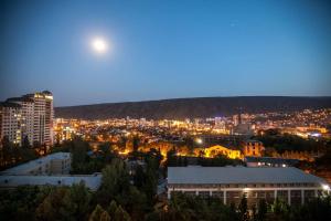 een uitzicht op een stad 's nachts met de maan bij Spacious 2 bedroom apartment in Tbilisi City