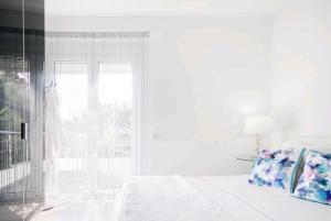 ポルト・ラフティにあるVilla Coralの白いベッドルーム(ベッド1台、窓付)