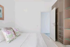 ポルト・ラフティにあるVilla Coralの白いベッドルーム(ベッド1台、クローゼット付)