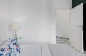 ポルト・ラフティにあるVilla Coralの白いベッドルーム(ベッド1台、ドア付)