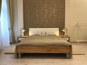 a bed in a bedroom with two lamps and a wall at Goldcentral Apartment in Budapest