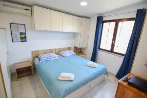 um quarto com uma cama azul com toalhas em F-Holiday Apartment em Zadar