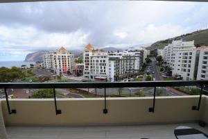 een balkon met uitzicht op de stad en de oceaan bij Duas Torres - Appartment in Funchal