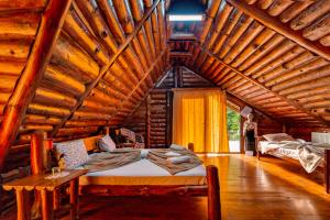 a bedroom with a bed in a log cabin at Raiul de pe Rau in Moroeni