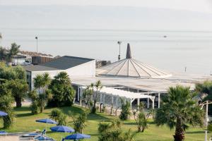 a building with blue umbrellas in front of the ocean at African Beach Hotel-Residence in Manfredonia