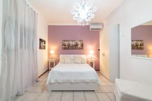 a bedroom with a white bed and a chandelier at Una terrazza sul golfo in Naples